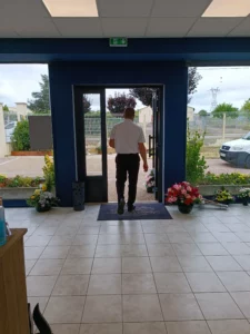 Un homme de dos sortant de l'agence funéraire Dubois avec discrétion.