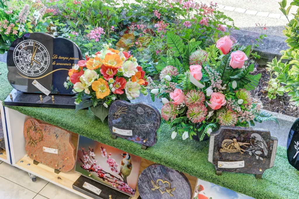 Exposition de plaques mortuaires et compositions florales en magasin.